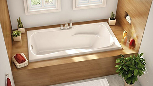 Une salle de bains avec une grande baignoire blanche à côté d'une fenêtre.