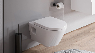 Des toilettes blanches à côté d'un miroir de salle de bains.